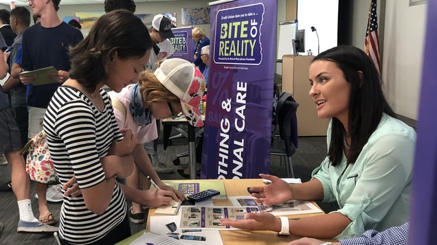 A SAFE employee talks with a girl during a Bite of Reality Fair.