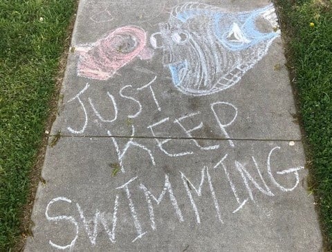 Chalk drawing that says Just Keep Swimming