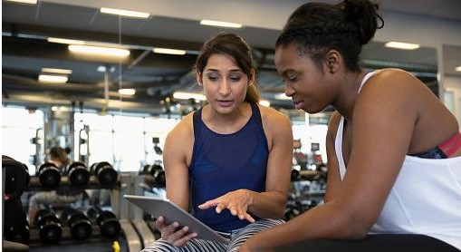 Women looking at tablet at a gym